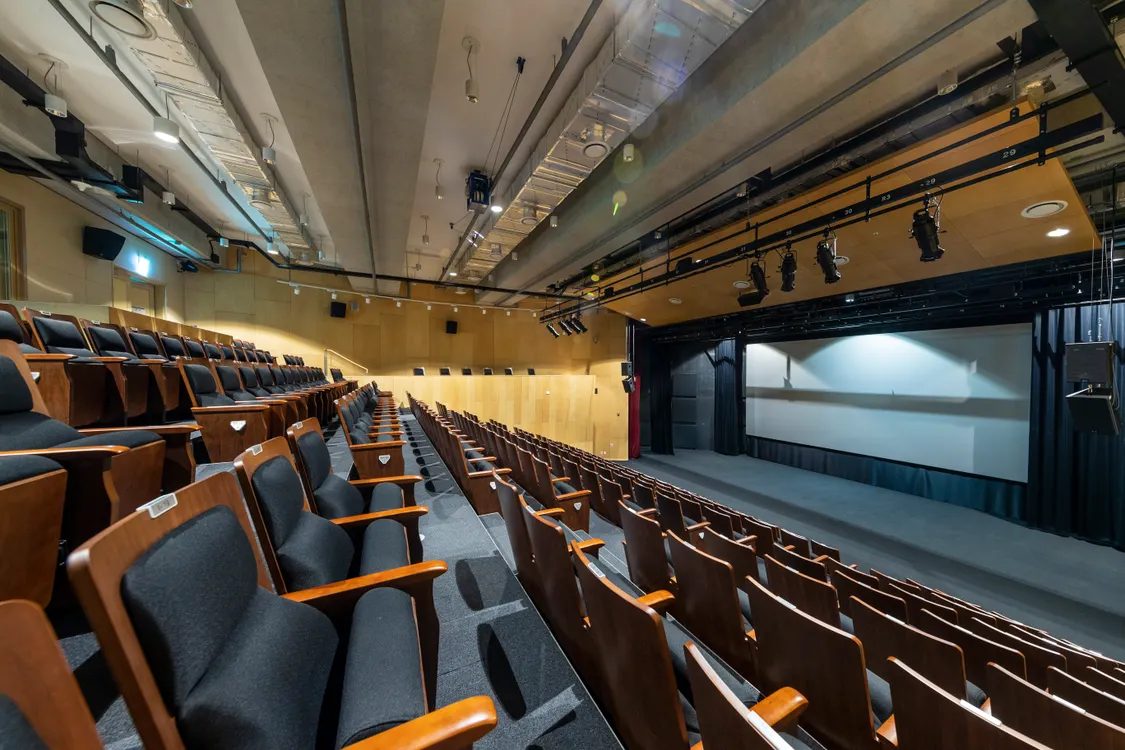 Warm auditorium with rows of wooden seats