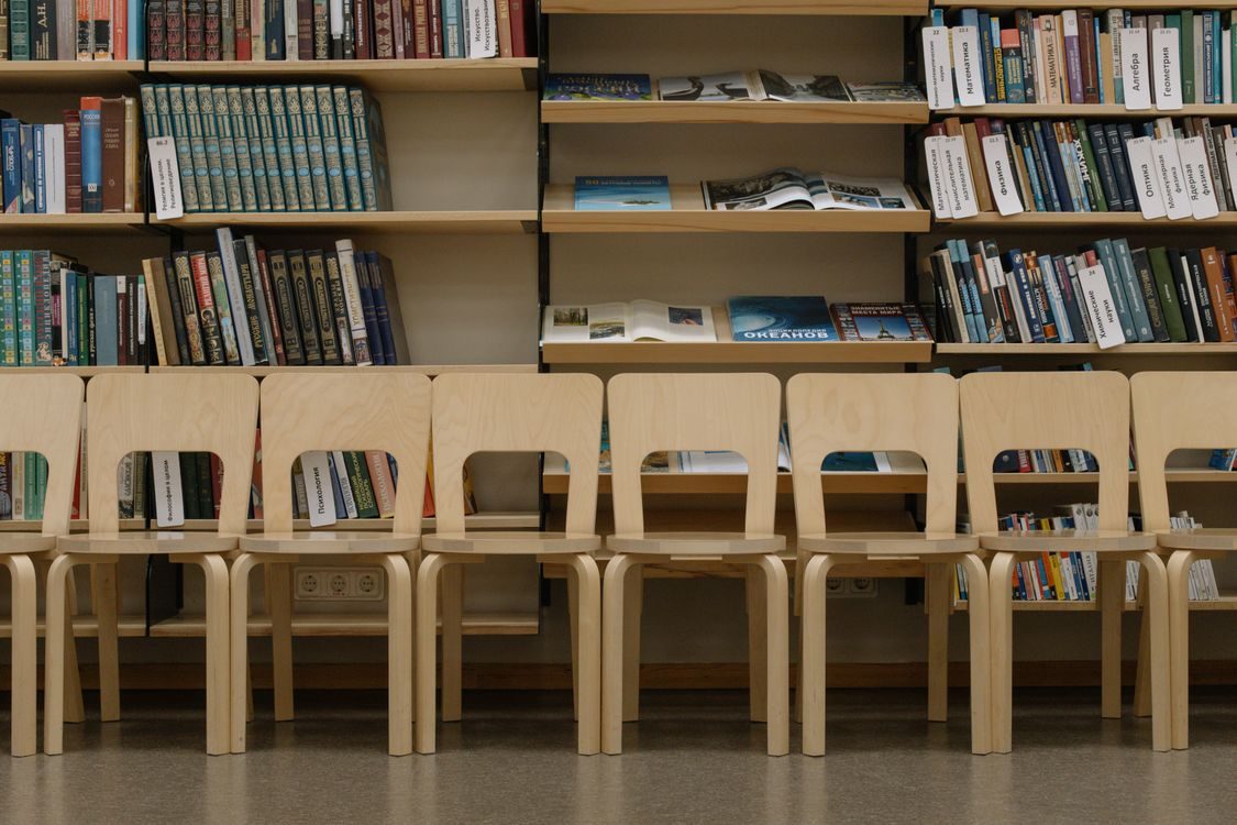 Library interior with wooden tables and bookshelves